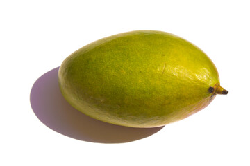 a green mango lies on a white background