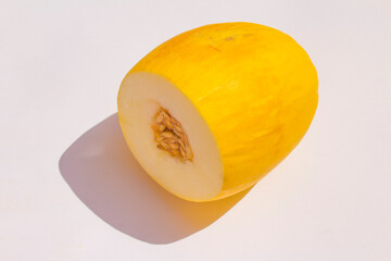 a sliced yellow melon is lying on a white background