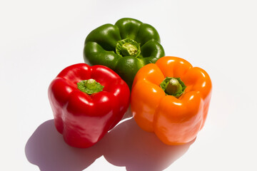 three different colored peppers: red, green and yellow peppers lie on a white background