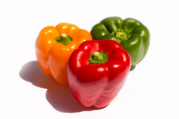 three different colored peppers: red, green and yellow peppers lie on a white background