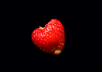 the strawberry lies on a black background