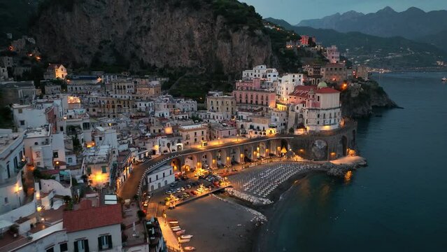aerial view of Amalfi town at night in Italy, famous Amalfi coast in the evening, touristic mediterranean town on the coast near Naples