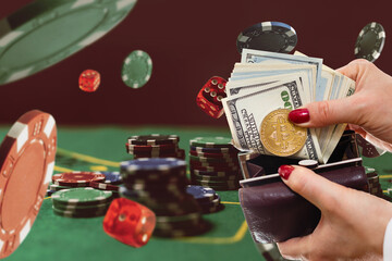 Bitcoin gold coin with poker chips on a green poker table against black background. Blockchain casino. Online gambling