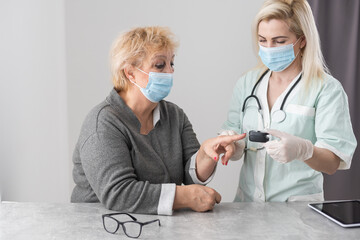 Doctor examining patient with fingertip pulse oximeter