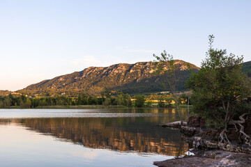 Fototapeta na wymiar Vue sur le Mont Liausson depuis les bords du Lac du Salagou au coucher du soleil