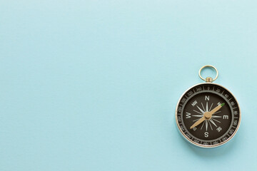 Vintage compass on light blue background. Journey and adventure concept. Flat lay, top view.