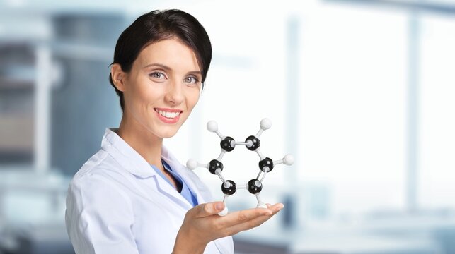 A young scientist looking at a molecular structure model.