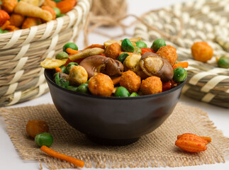 chinese mixed crackers served in a bowl isolated on napkin side view of nuts on grey background