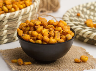 Salted corn served in a bowl isolated on napkin side view of nuts on grey background
