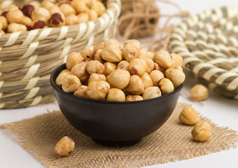 hazelnut served in a bowl isolated on napkin side view of nuts on grey background