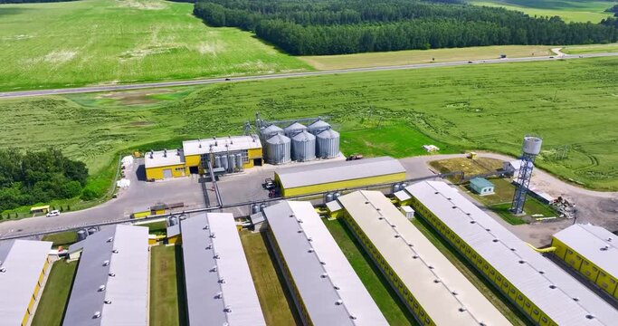 aerial view and circular votion around silos and agro-industrial livestock complex on agro-processing and manufacturing plant with modern granary elevator. chicken farm. rows of chicken coop