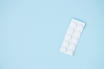 medical pills on blue background. top view copy space