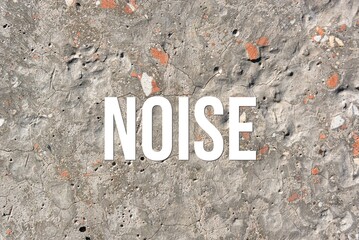 noise - word on concrete background. Cement floor, wall.