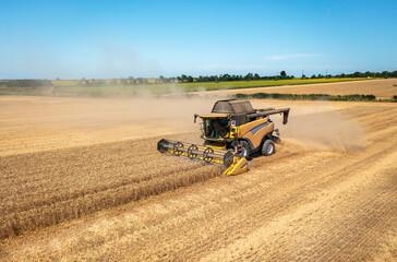 Combine harvester on a wheat field with blue sky.