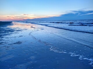 Naklejka na ściany i meble Blue Beach Ocean Sunrise Over Reflecting Traced Foam and Waves
