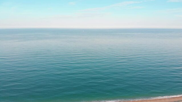 Cars driving on scenic road through the ocean - aerial drone shot