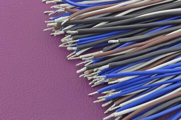 Copper electrical wires on natural colored leather close-up.