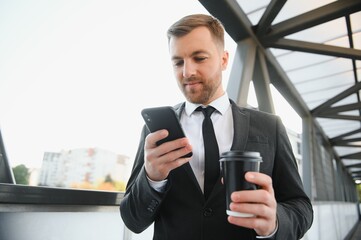 Takeaway coffee. Walk and enjoy fresh hot coffee. Waiting for someone in street. Man bearded hipster drink coffee paper cup. Businessman well groomed enjoy coffee break outdoors urban background