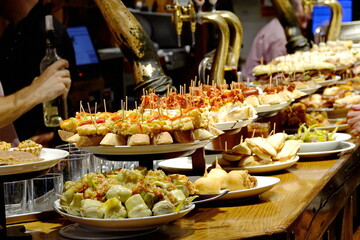 Naklejka premium A tapas bar in San Sebastian with delicious pintxos, the traditional appetizers of the Basque country. San Sebastian, Spain 