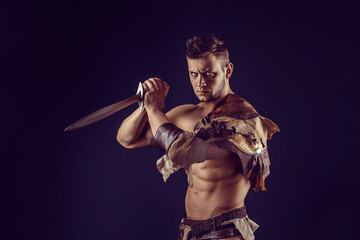 Fototapeta na wymiar Portrait of handsome muscular gladiator with sword. Isolated. Studio shot. 