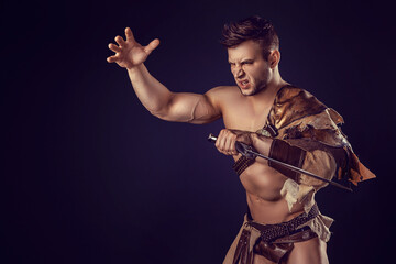 Fototapeta premium Portrait of handsome muscular gladiator with sword. Isolated. Studio shot. 