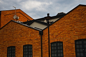 Fototapeta na wymiar Stary budynek z czerwonej cegły . Z oknami w stylu przemysłowym .