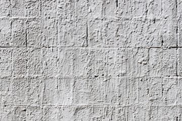 Painted brick wall close-up, peeling paint, grey color