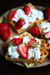 Strawberries with cream on Viennese waffles. Summer dessert with strawberries.