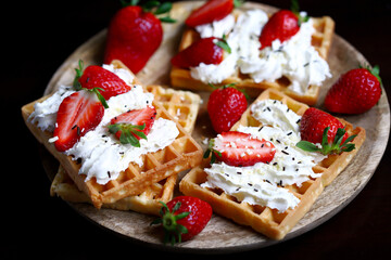 Strawberries with cream on Viennese waffles. Summer dessert with strawberries.