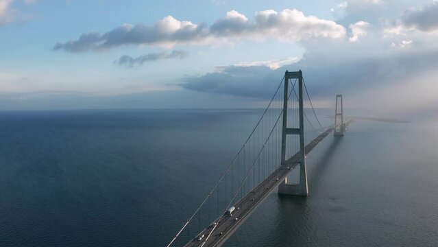 Car traffic at the Great Belt suspension bridge (&Oslash;stbroen) highway at sunset, Denmark