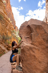 Latina girl rock climbing and bouldering side of boulder in Zion National Park