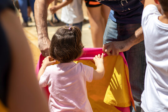 The confinement of the bulls, is celebrated in the Patron Saint Festival of San Juan del Puerto, from June 19 to 23. A little girl from behind holding a bullfighting cape.