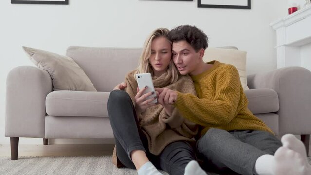 Happy young millennial couple hugging looking at camera standing at home. New modern apartment owners, real estate buyers embracing posing in living room, portrait. Mortgage investment concept