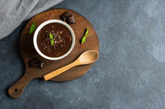 Chocolate cocoa pudding, mousse in ceramic cup on rustic table, supangle