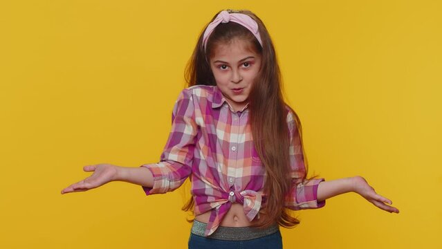 I dont know what to say. Confused preteen child girl kid feeling embarrassed about ambiguous question, having doubts, no idea being clueless and uncertain. Little toddler children on yellow background