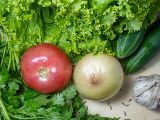 Lettuce, sour cream, vegetables. Greens for soup on the table. Greenery from the garden. Cutting board. Cooking. Vegan food. Useful product. Vegetable ingredients for lunch.