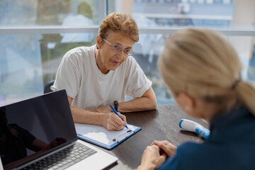 Female patient signing treatment agreement in doctor's office in clinic. High quality photo