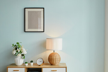 Background image of minimal home decor with flowers and mock up picture on wall, copy space - obrazy, fototapety, plakaty