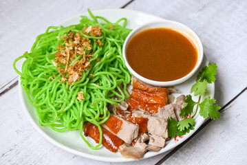 Jade noodle Asian Thailand food , roasted duck with jade noodle on white plate and duck sauce, green noodles Chinese food