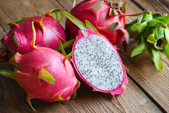 dragon fruit cut half on wooden with pitahaya background , fresh dragon fruit tropical in the asian thailand healthy fruit concept