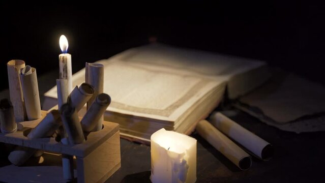 Historical period book and candlelight image.
Reading a book by candlelight in the historical era.
