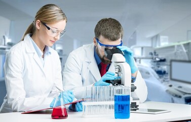 Young scientists conducting research investigations in a medical laboratory, a researcher in the...
