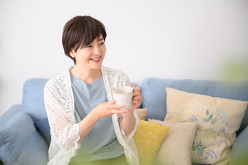 Woman relaxing with a cup of coffee, etc.