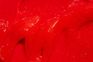 Red gel texture. Cosmetic clear liquid cream smudge. Skin care product sample closeup. Toothpaste...