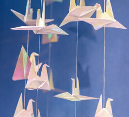 many Paper crane origamis on blue background