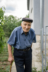 one man senior caucasian male pensioner old farmer standing alone outdoor by his home in summer day looking to the camera confident real people copy space