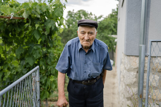 one man senior caucasian male pensioner old farmer standing alone outdoor by his home in summer day looking to the camera confident real people copy space