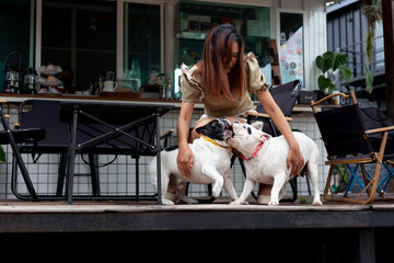 Asian woman plays with French bulldog in cafe
