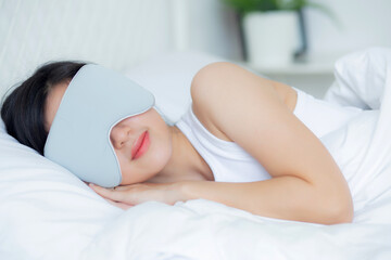 Obraz na płótnie Canvas Beautiful young asian woman wearing cover eye and sleeping on bed with head on pillow comfort and happiness in the bedroom at home, girl with relax and leisure for wellness, lifestyles concept.