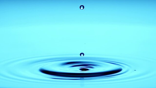 A single drop of water falling into a pool of water in slow motion.